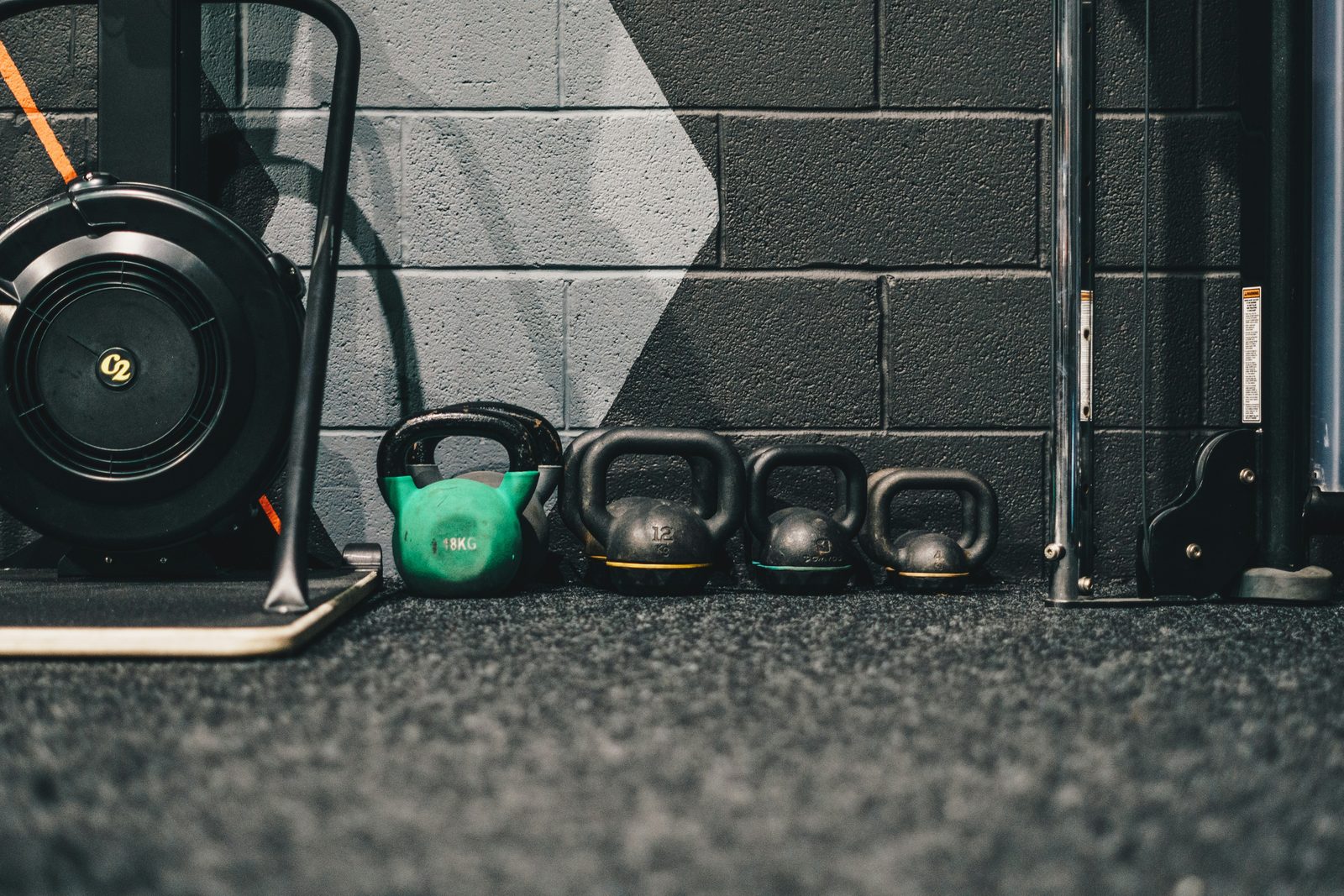 Rowing machine and kettlebells in a gym, representing cardio versus weight training equipment