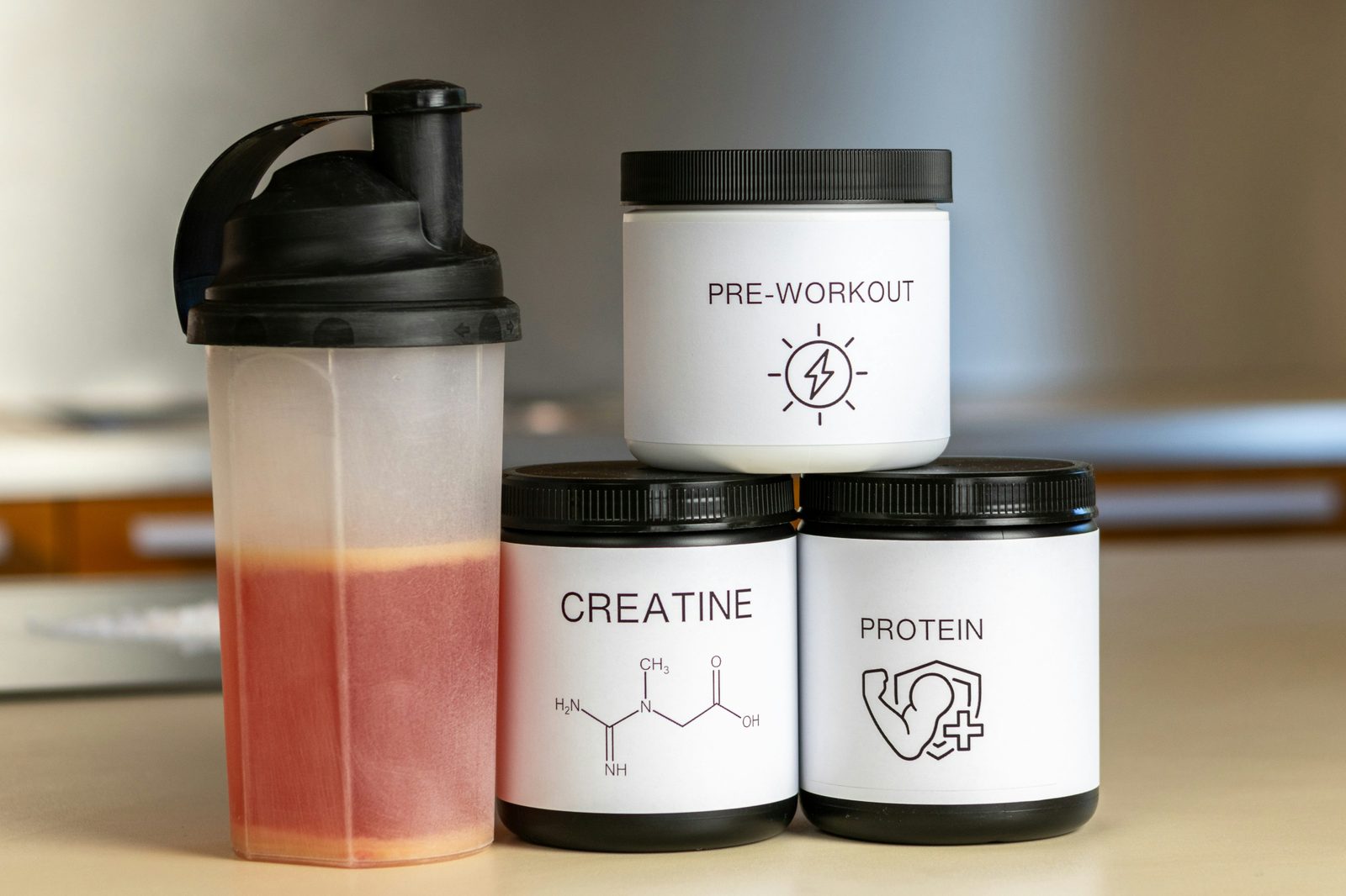Creatine, pre-workout, and protein supplement jars with a shaker bottle