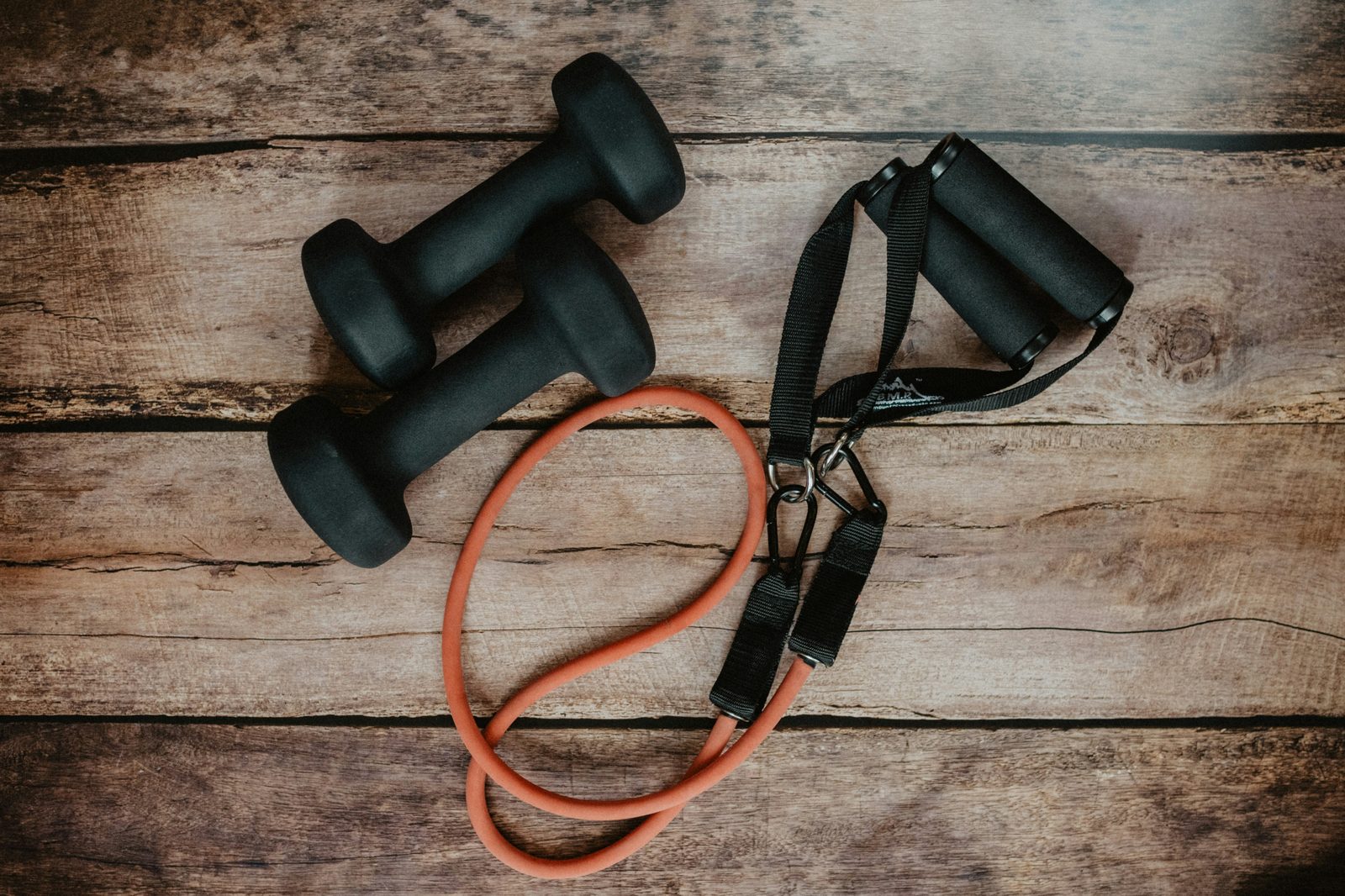Dumbbells and resistance band equipment, representing free weights versus machine training