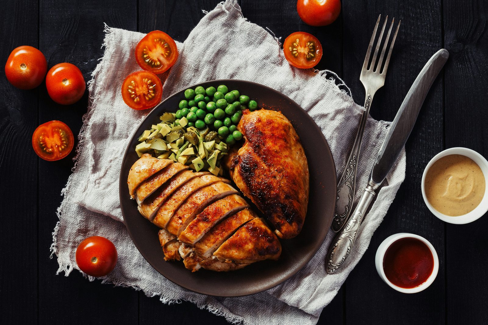 Grilled chicken breast with peas and tomatoes, a high-protein meal